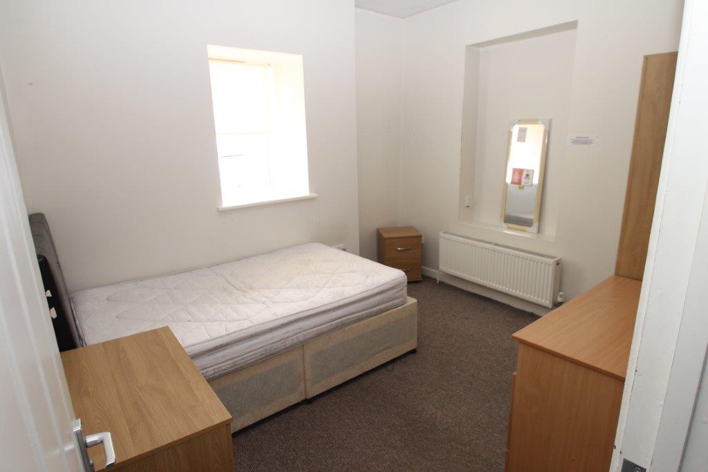 Second student bedroom with double bed, chest of drawers, two bedside tables and mirror