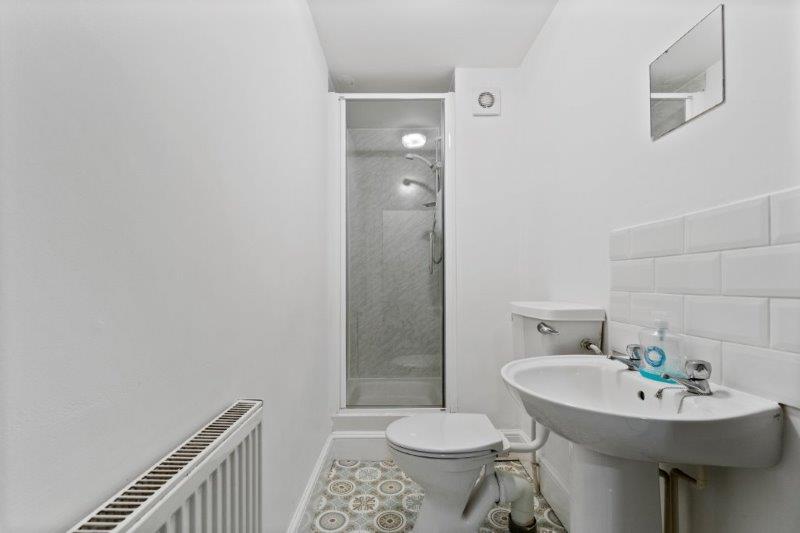 shared bathroom with shower and mirror above sink