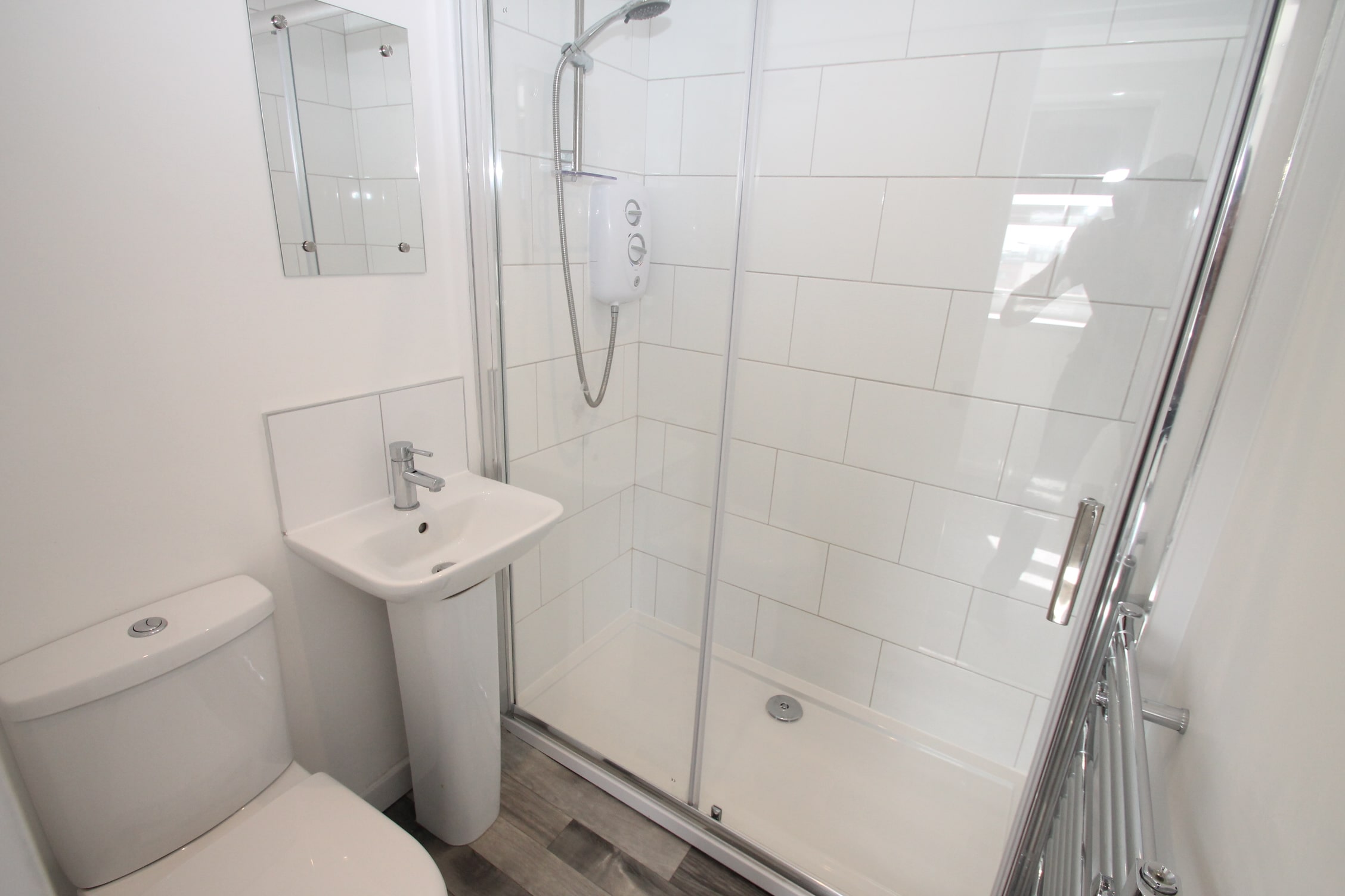 En-suite bathroom with shower and towel rack radiator